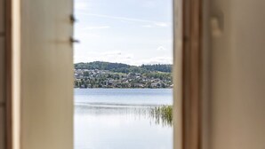 A room with a view of a lake and a distant town.
