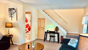 A living room with a sofa, a coffee table, a lamp, a desk, and a staircase. - 2-bedroom apartment just a short walk from the Saint Lawrence River.
 (Clayton)