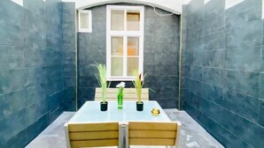 A small room with a table and chairs, a window, and dark tiled walls. - Ottakring Gem 4-BR Retreat/Breathtaking City Views (Vienna)