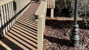 A two-story building with a balcony on the second floor, a wooden deck leading to the entrance, and a street lamp nearby. - JayBird's Nest at Rumbling Bald in Lake Lure w/ pools, sauna, lake, spa, golf  (Lake Lure)