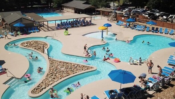 A pool area with multiple swimming pools, lounge chairs, and umbrellas. - JayBird's Nest at Rumbling Bald in Lake Lure w/ pools, sauna, lake, spa, golf  (Lake Lure)