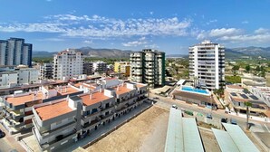 A residential area with multi-story buildings, a swimming pool, and a clear sky.