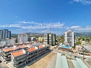 Zona residencial con edificios de varios pisos, una piscina y cielo despejado.
