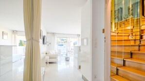 A bright, modern interior with a staircase, a white sofa, and a dining area. - Apartment 'Cannes Center Sea and Sky' with Sea View, Private Terrace and Air Conditioning (Cannes)