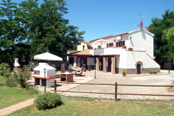 A house with a patio, outdoor furniture, and a small garden.