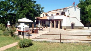 Une maison avec un patio, du mobilier d’extérieur et un petit jardin.