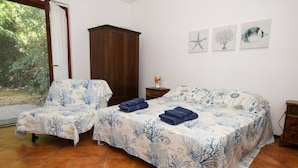 Une chambre avec deux lits, une armoire et des œuvres d’art accrochées au mur.