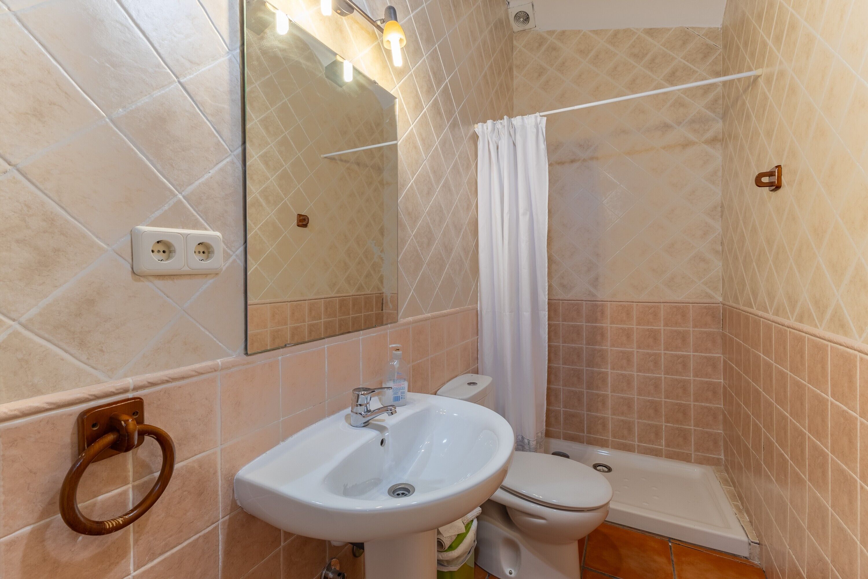 Een badkamer met een wastafel, toilet en douchehoek.