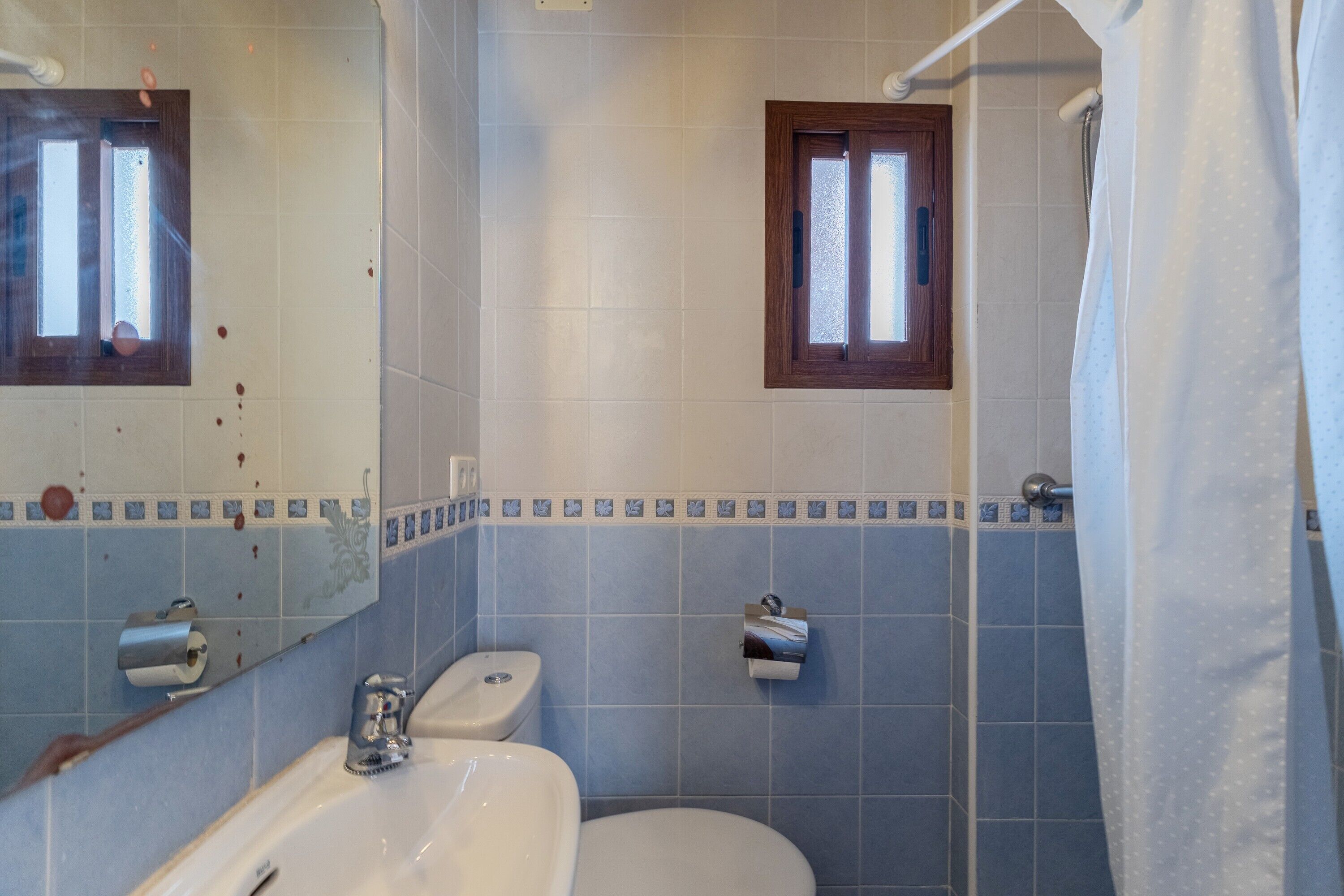 Une salle de bain équipée d’un lavabo, de toilettes et d’un rideau de douche.