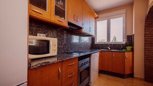 A kitchen with wooden cabinets, a microwave, a stove, and a dishwasher.