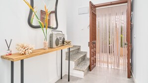 A hallway with a wooden console table, a mirror, a radio, and a decorative plant.