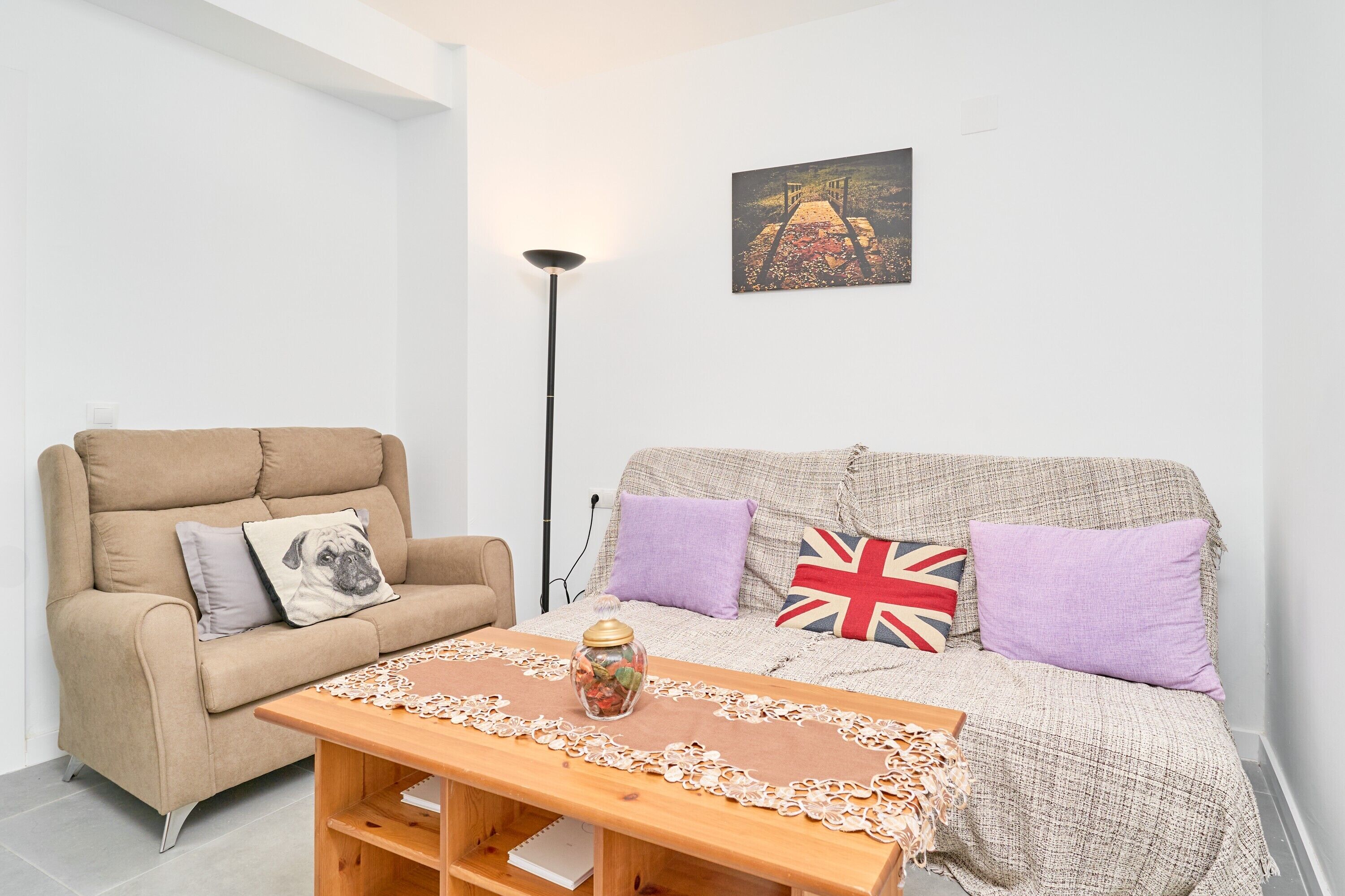 Un salon avec un canapé, un fauteuil, une table et une lampe.