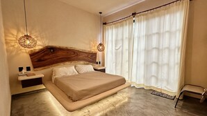 A modern bedroom with a large bed, wooden headboard, bedside tables, and a hanging light fixture. - "Jade" Premium Suite, AC, Private pool (Tulum)