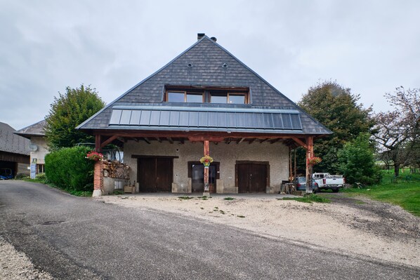 A building with a pitched roof, a porch, and two doors.
