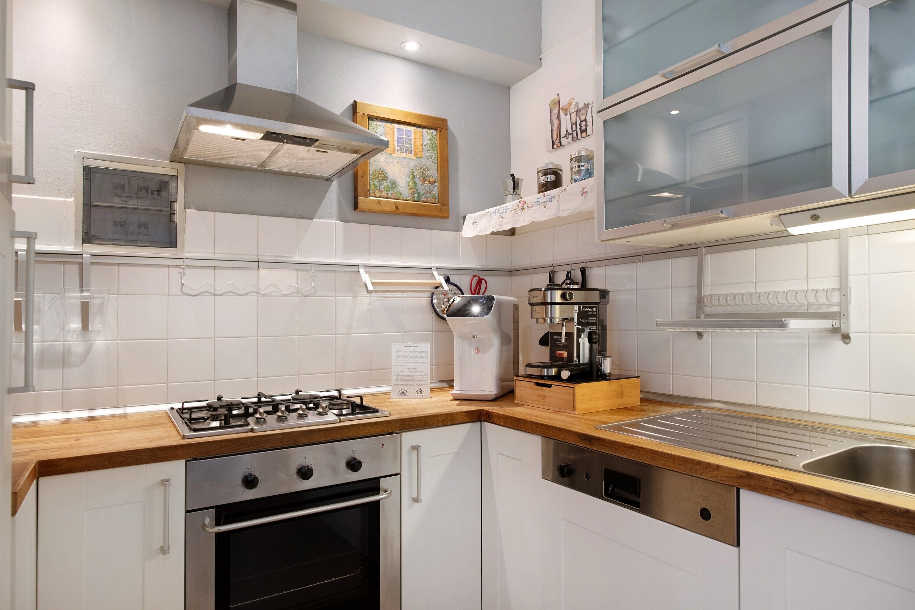 Una cocina moderna con estufa a gas, horno y cafetera.