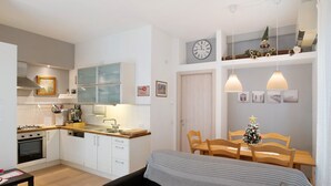 A compact living space with a kitchenette, dining area, and a bed.