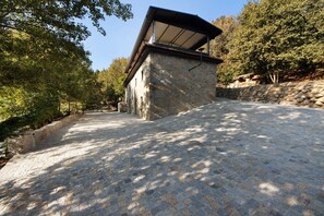 Un bâtiment en pierre doté d’un toit en pente et d’un chemin pavé menant à l’entrée.