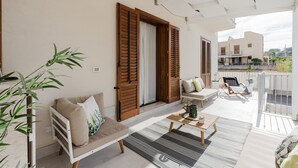 A balcony with a sofa, a small table, and a chair.