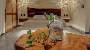 A bedroom with a wooden headboard, a bedside table, and a nightstand. - "Lotus" Tulum Jungle Suite | Fast Wifi | Private Balcony (Tulum)