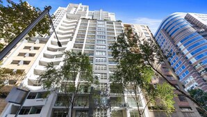 Un moderno edificio de gran altura con varios balcones y fachada de vidrio.
