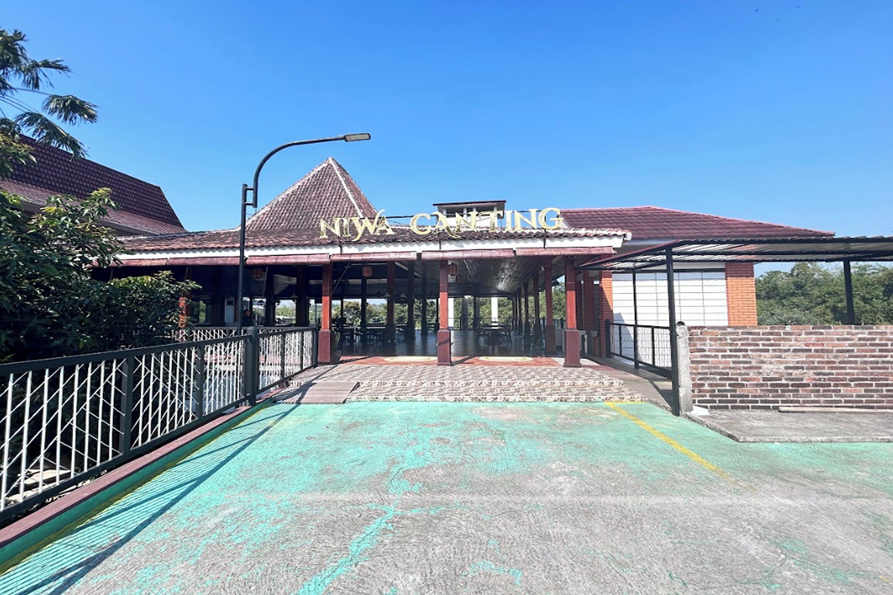 A building with a sign reading "NIWA CANTING" and a covered entrance area.