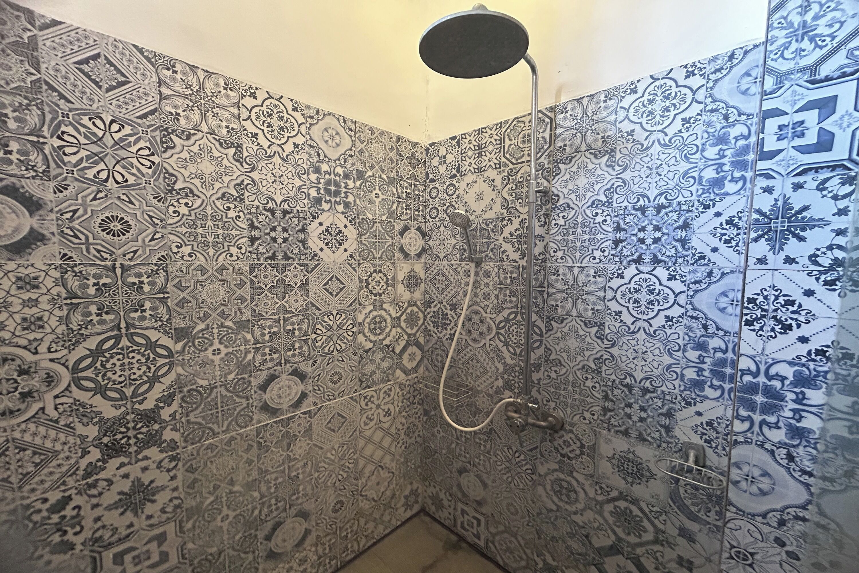 A bathroom with intricate tile patterns and a shower.