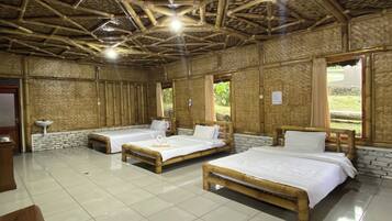 A room with three wooden beds, a white tiled floor, and a bamboo ceiling.