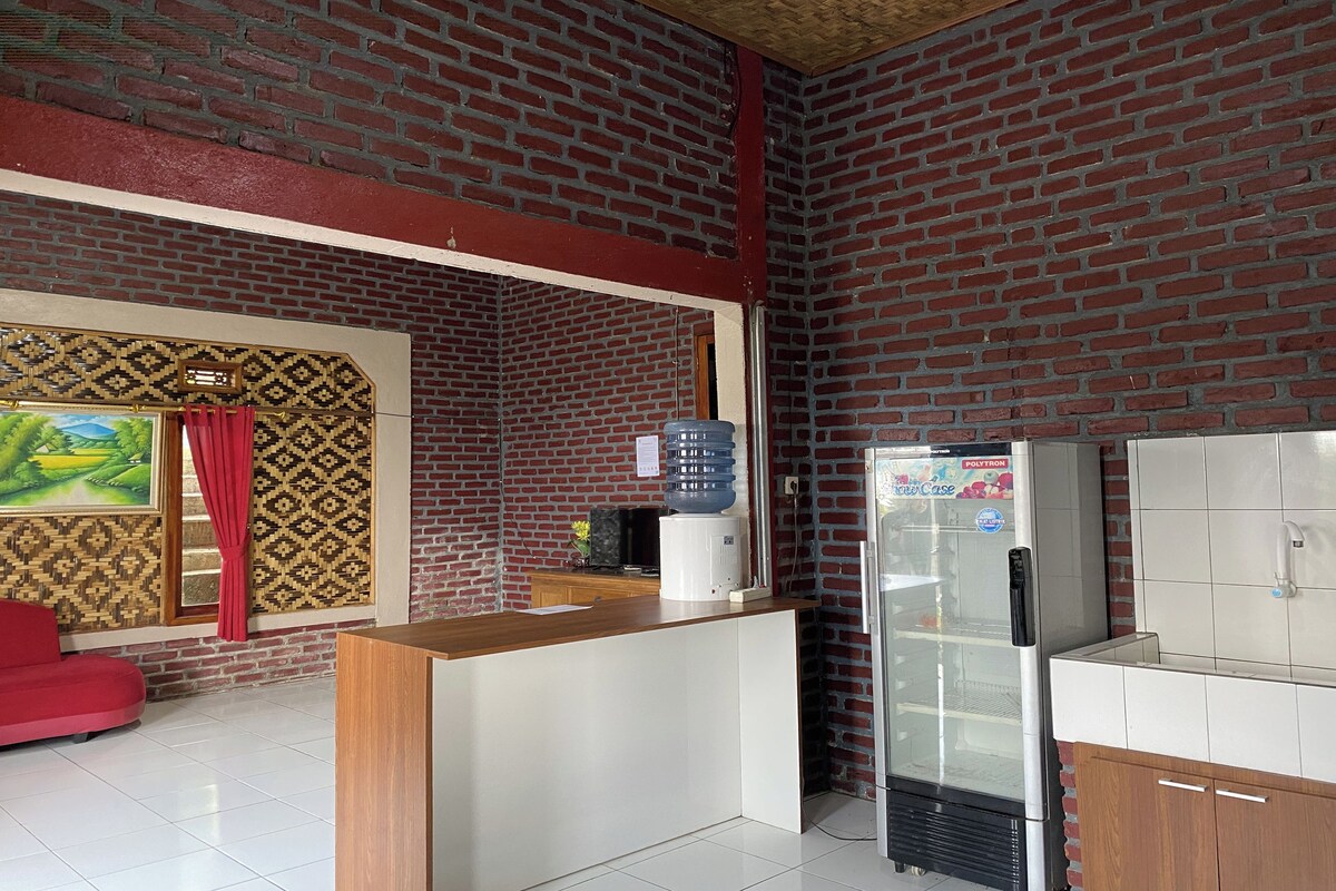 A modern kitchen with a brick wall, a refrigerator, and a counter.