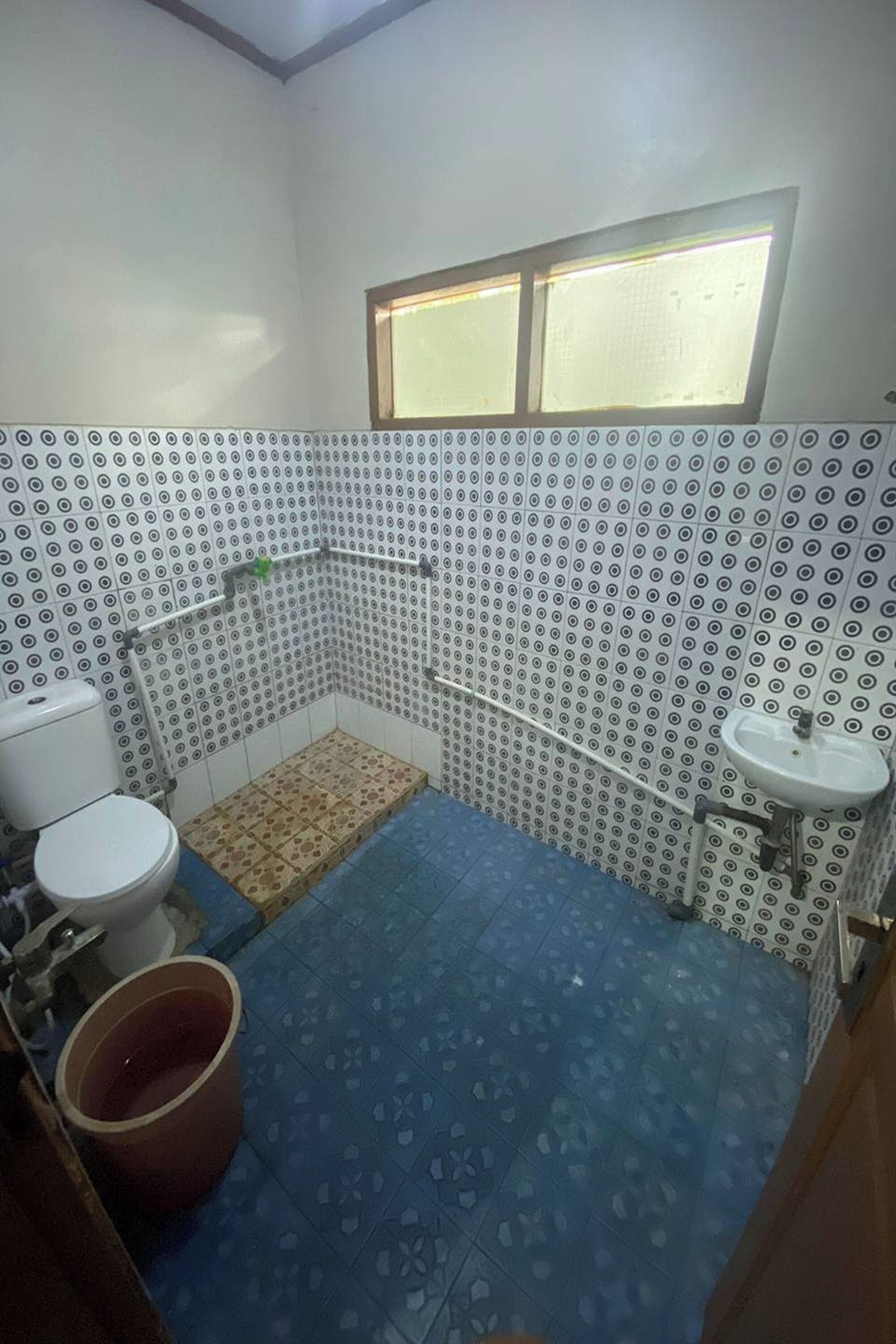 A bathroom with a toilet, sink, and shower area.
