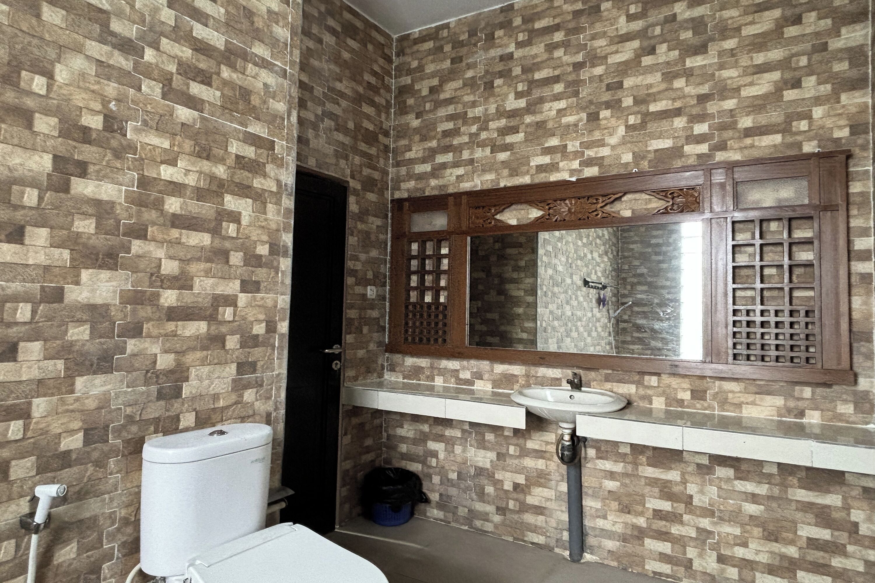 Une salle de bain avec des toilettes, un lavabo et un miroir.