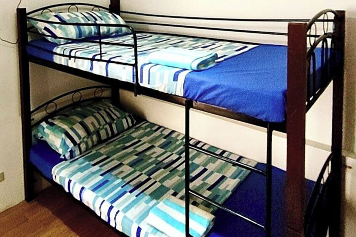 A bunk bed with two levels, a ceiling fan, and a light fixture.