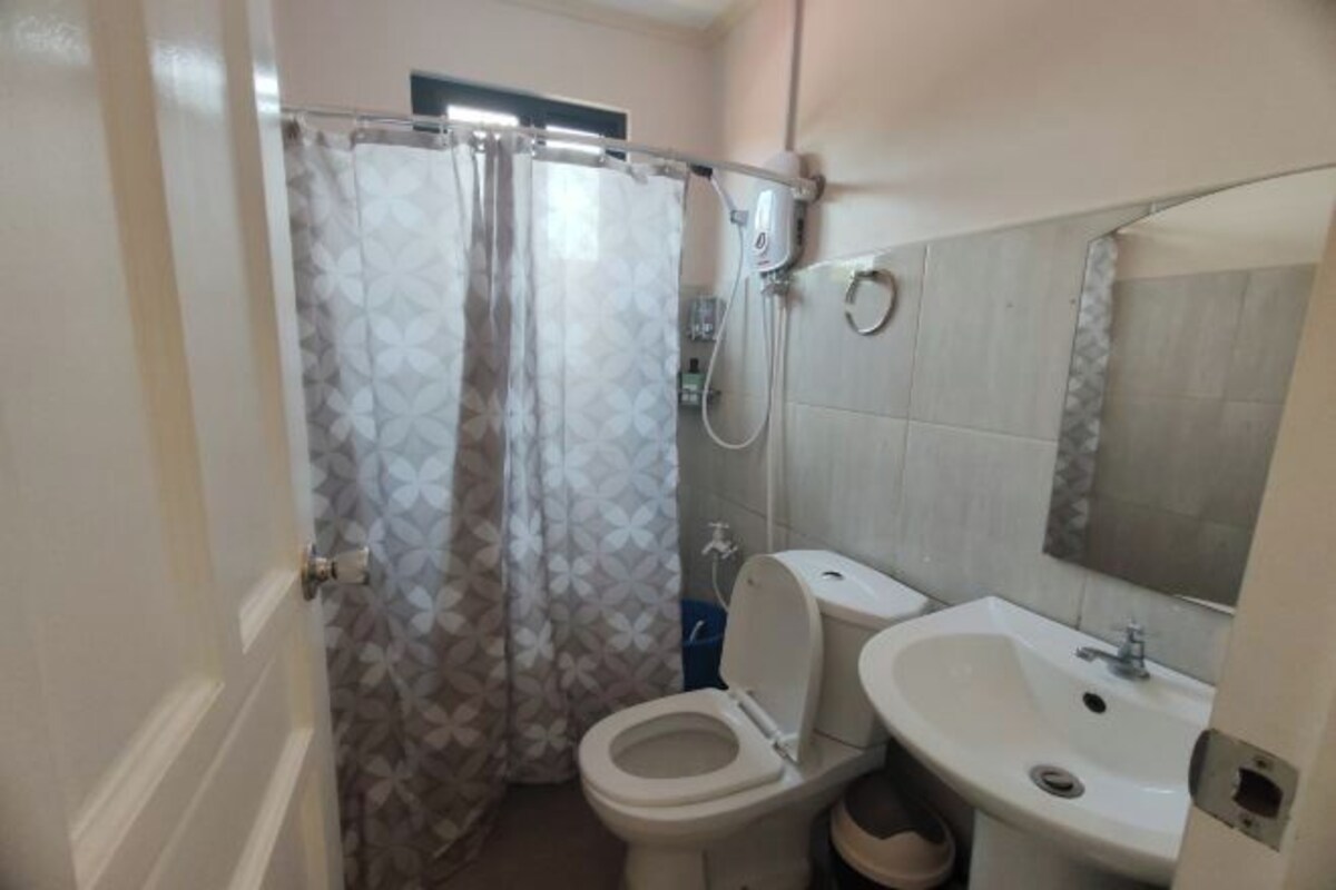 Une salle de bain avec des toilettes, un lavabo et un rideau de douche.