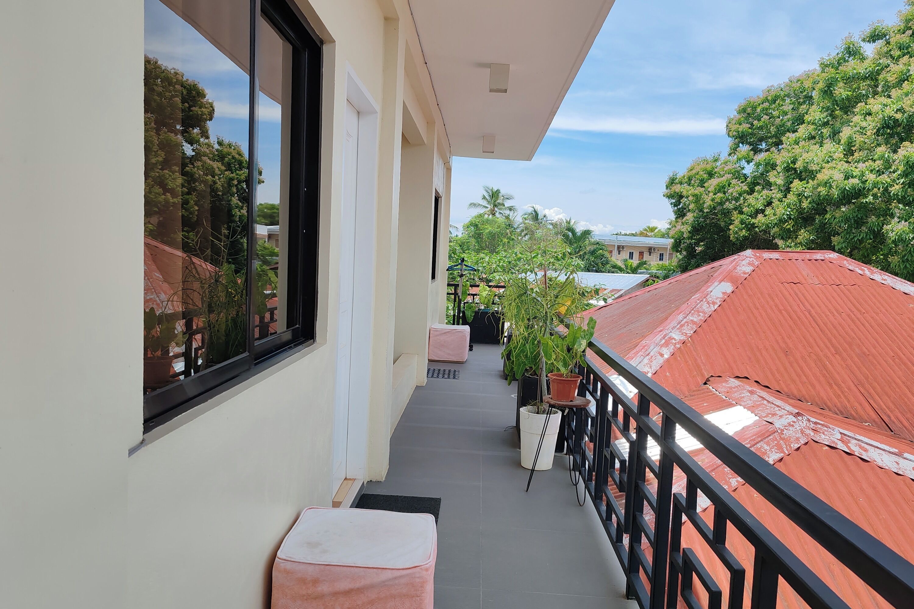 A balcony with a view of neighboring buildings and trees.
