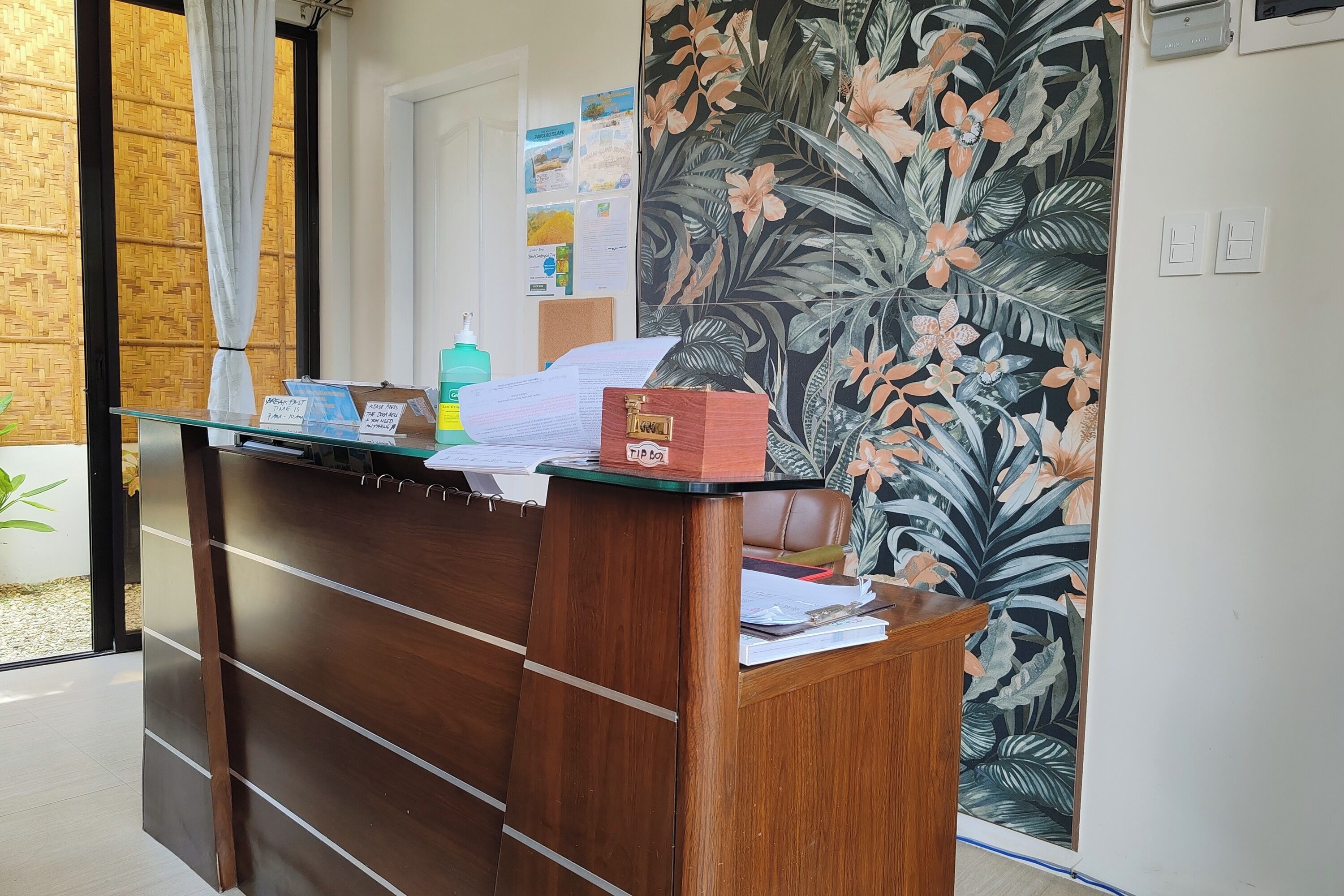 A wooden reception desk with papers and a bottle.
