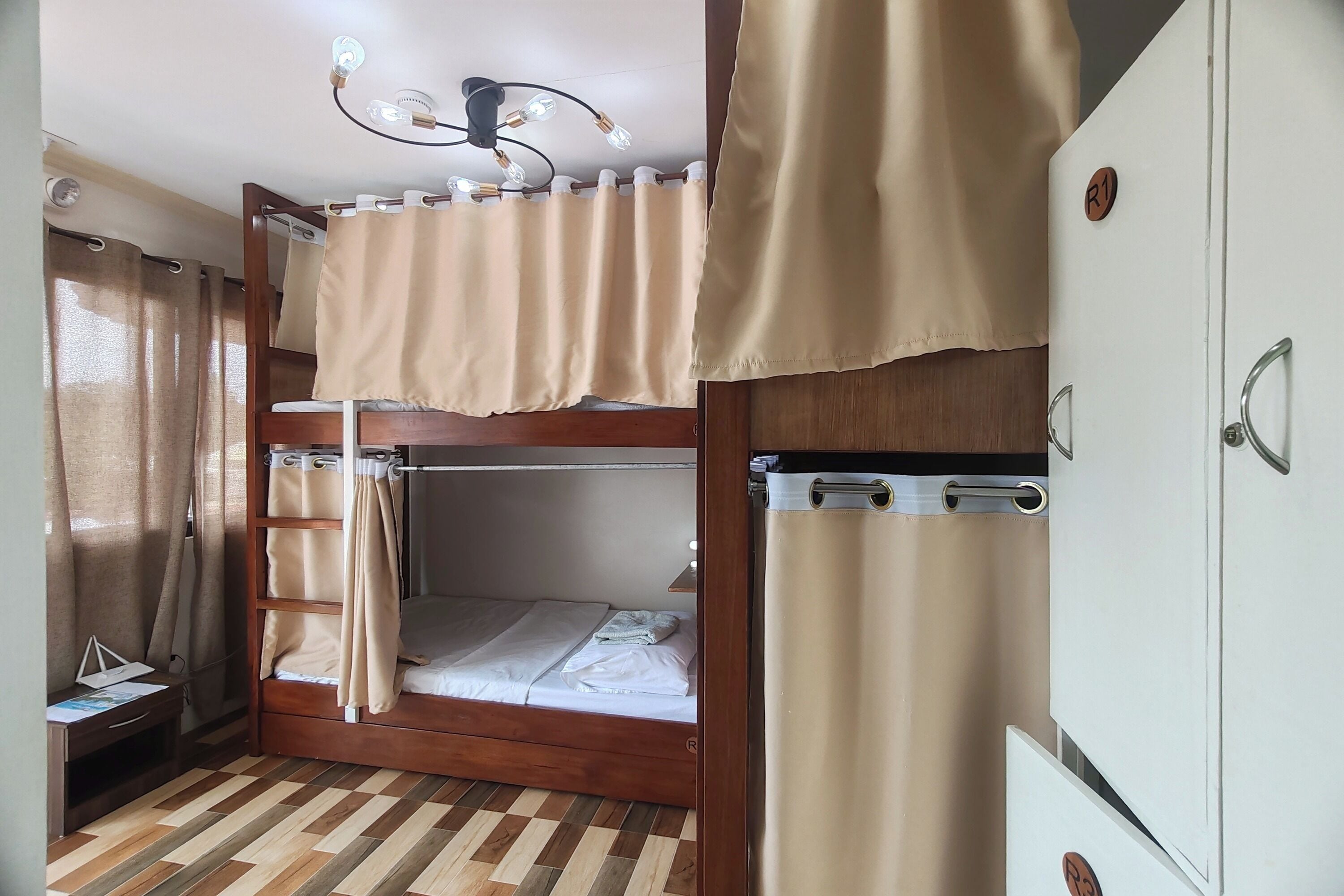 Habitación con literas, cabecera de madera, escritorio y armario.