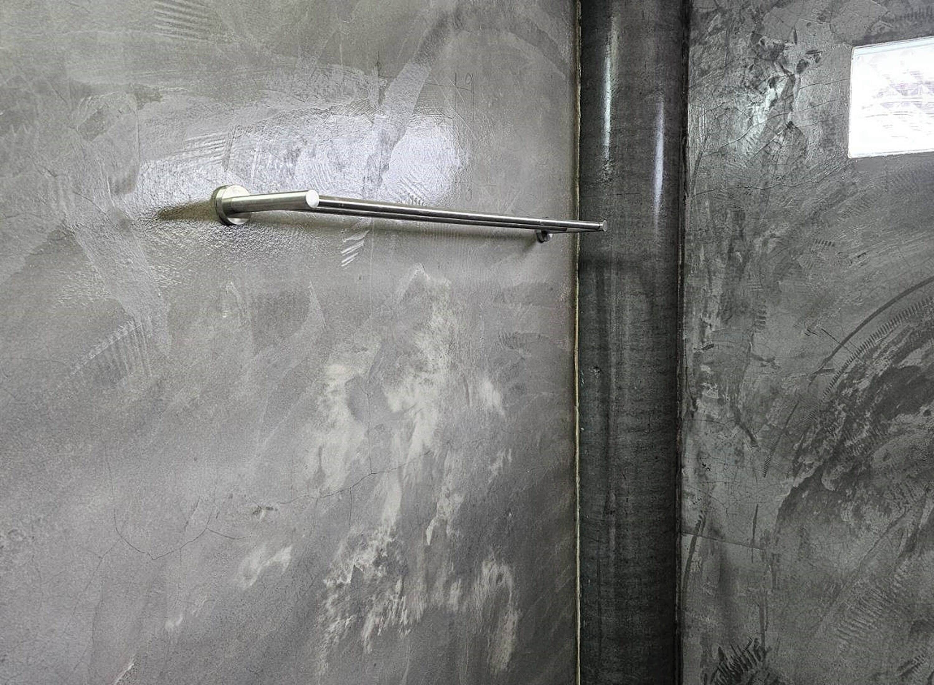 A metallic door with a horizontal handle and a vertical handle.
