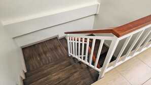 A staircase with a white railing and dark wooden steps. - Reezq Hostel (Bangkok)