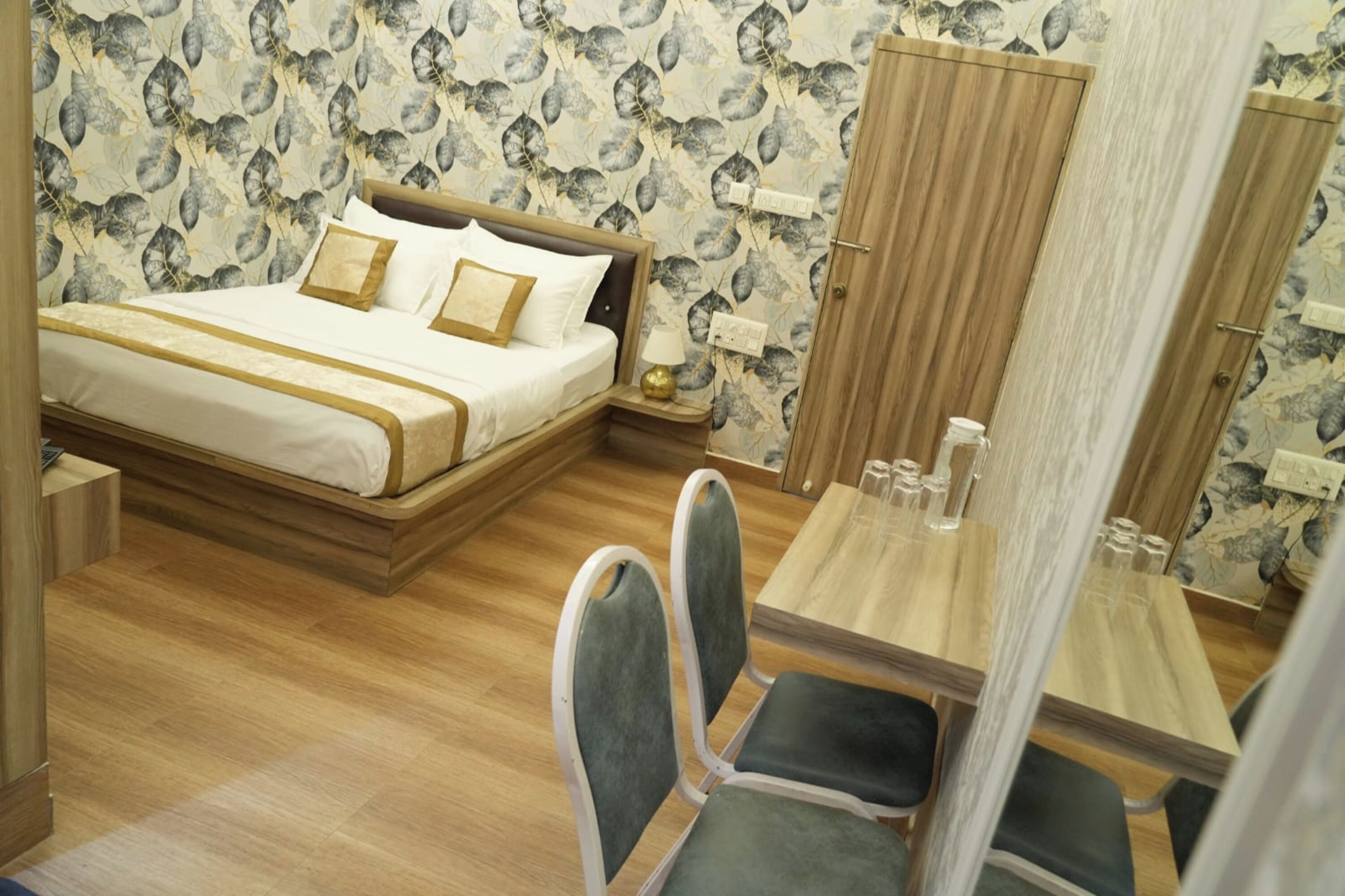 A bedroom with a bed, bedside table, lamp, and a wooden wardrobe.