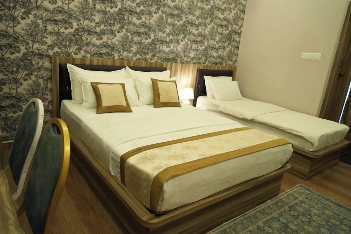 Una cama doble con estructura y cabecero de madera, una cama individual con estructura de madera y una silla.