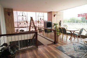Une piÚce spacieuse avec un escalier en bois, un balcon offrant une vue agréable et un coin repas comprenant des chaises et une table.