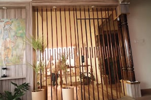 Una habitación con piso de madera, un cuadro grande en la pared y una planta en maceta.