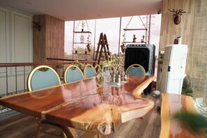 Une table à manger en bois avec des chaises, une échelle et un réfrigérateur, le tout dans une piÚce offrant une vue agréable.