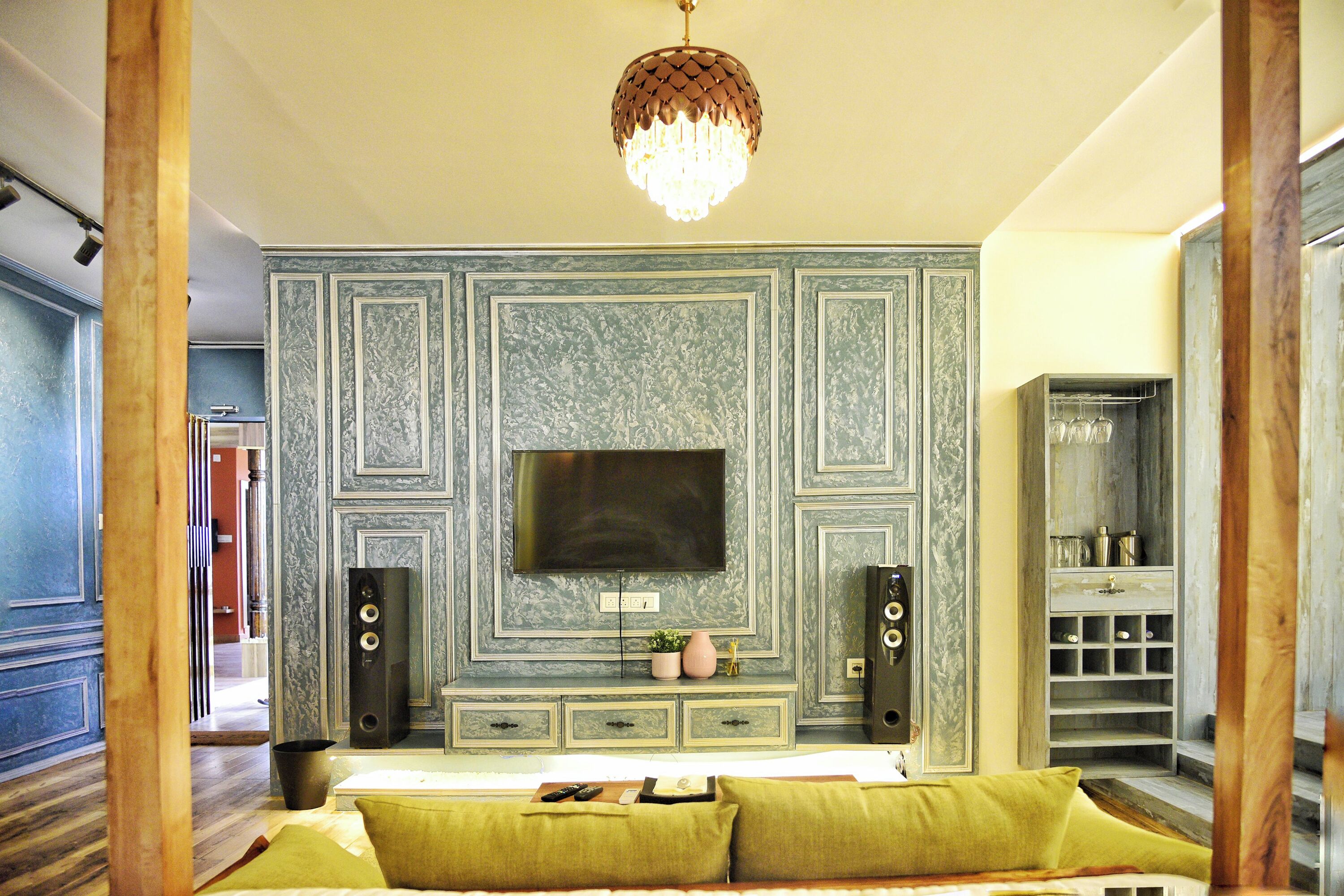 A bedroom with a large bed, a TV mounted on the wall, and a wooden cabinet with shelves.