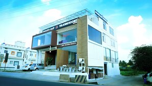 A modern building with a sign for 'Vilash Rooms' and 'Krishna Bhagya'.