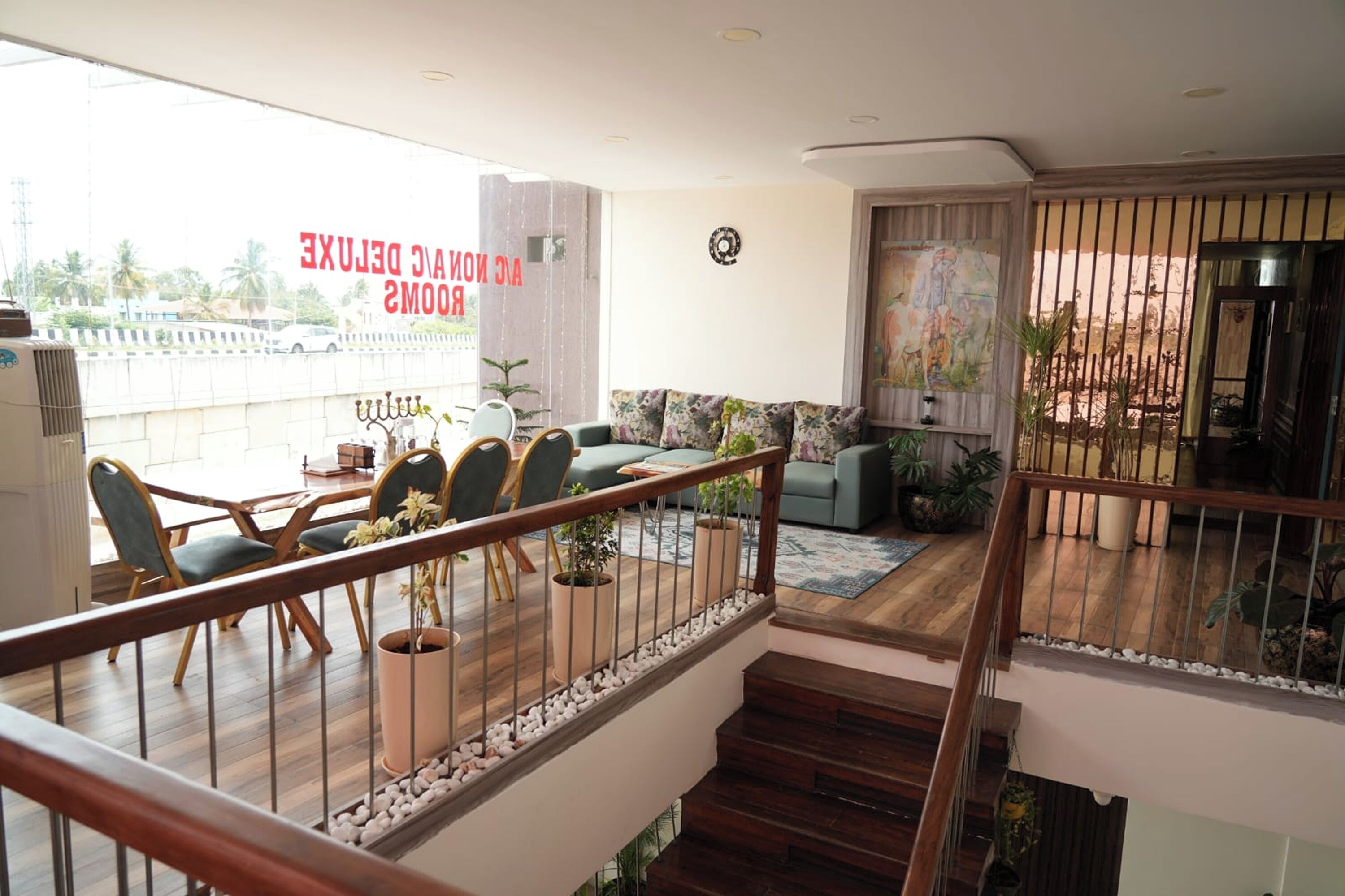 Un vaste espace de vie avec balcon, un ensemble de meubles de salle à manger et un escalier.