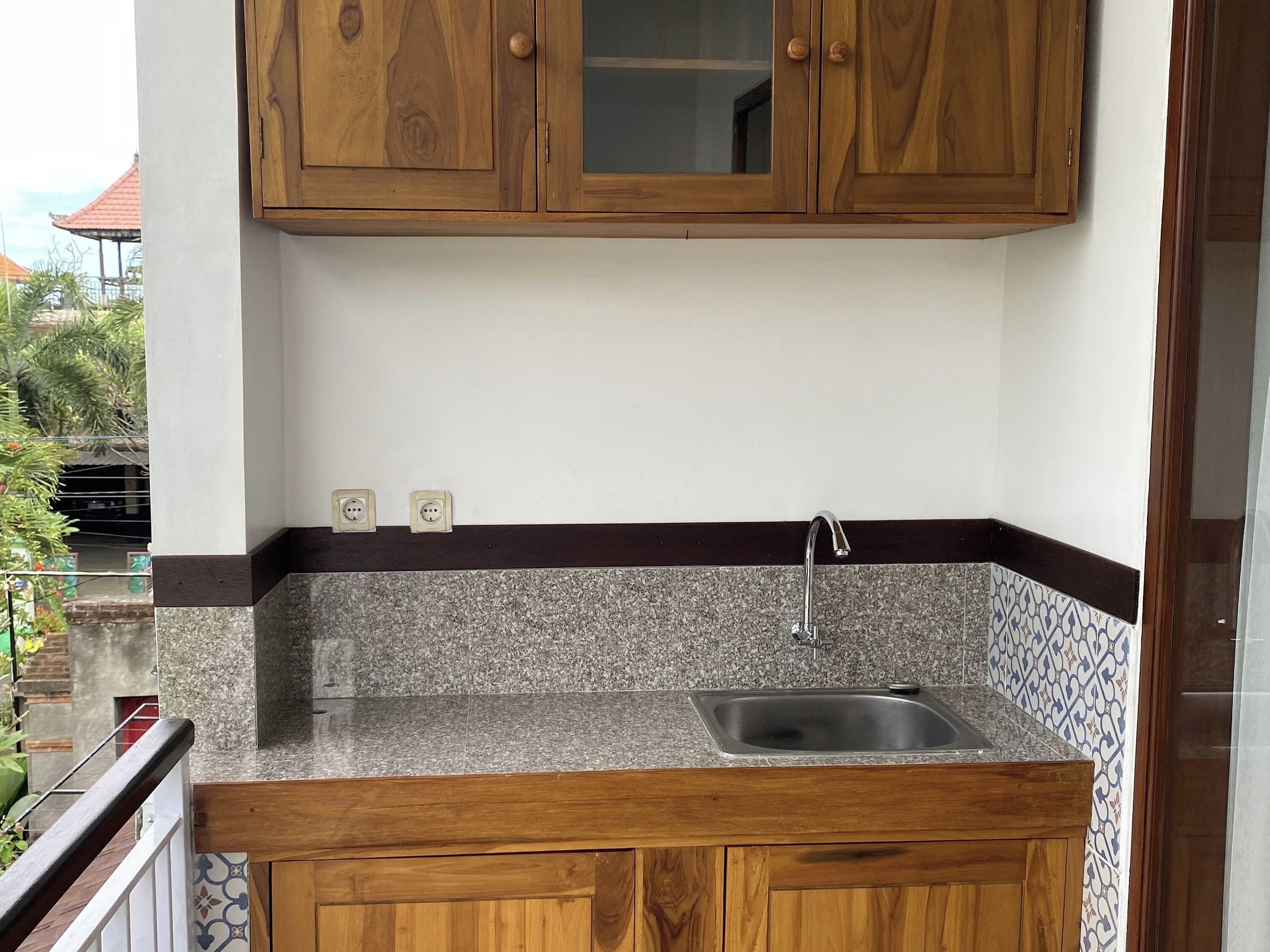 A kitchen with wooden cabinets, a granite countertop, and a stainless steel sink.