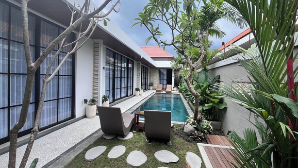 A modern house with a swimming pool, outdoor seating, and lush greenery. - Ranala Coliving (Keroboken Kelod)
