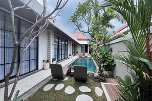 A modern house with a swimming pool, outdoor seating, and lush greenery. - Ranala Coliving (Keroboken Kelod)