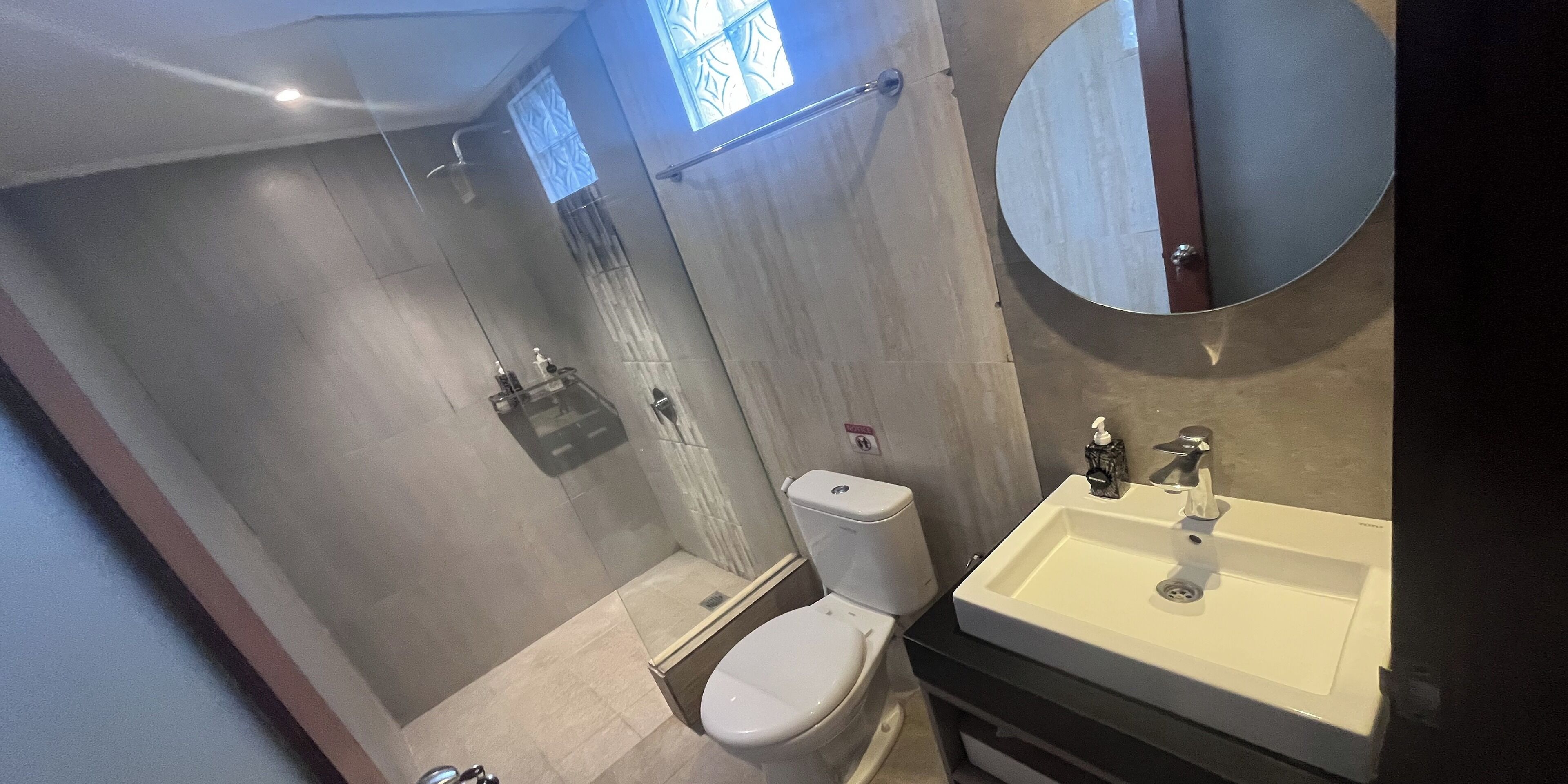 Un baño moderno con inodoro, lavabo y ducha.