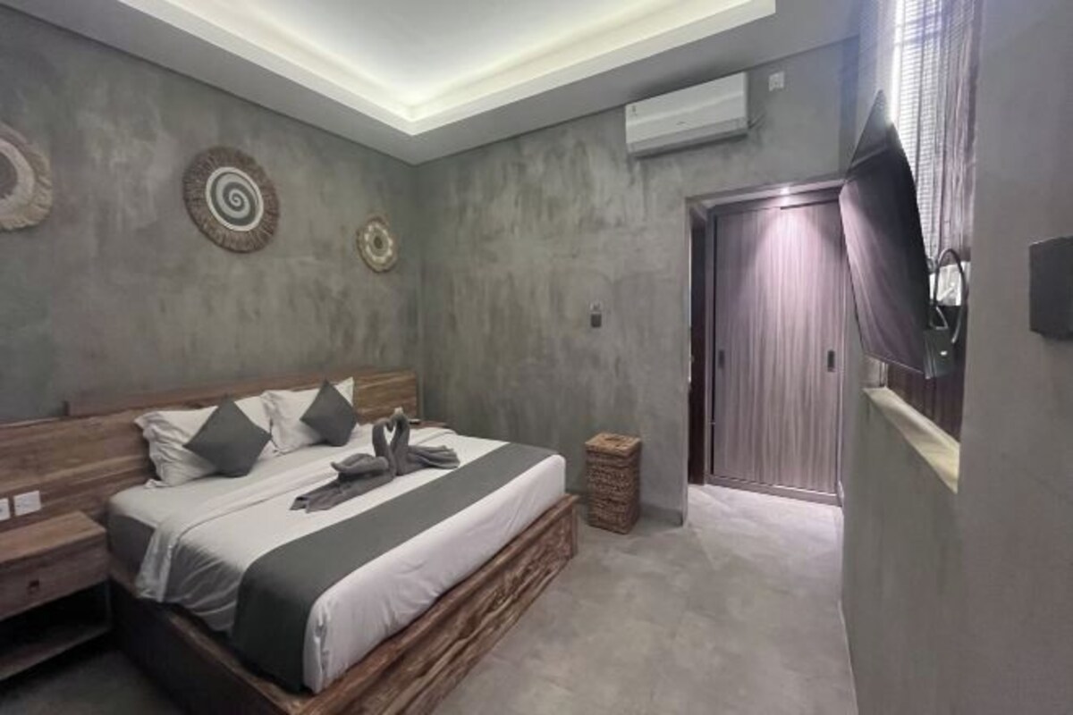 A bedroom with a bed, bedside tables, a wardrobe, and a ceiling light fixture.